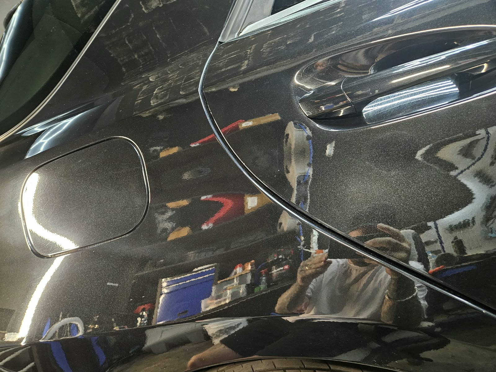 Hinteres Seitenteil eines schwarzen Autos nach der Politur mit verbessertem Glanz