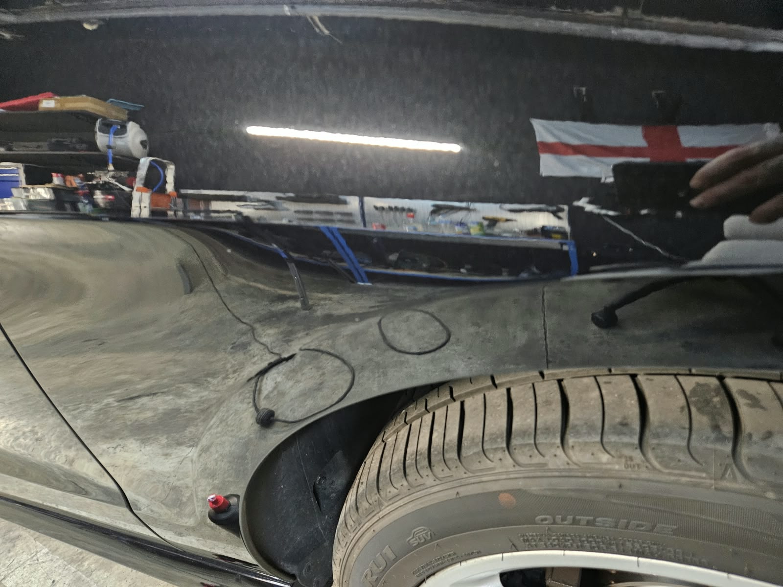 Radlauf eines schwarzen Autos nach Maschinenpolitur mit klareren Reflexionen